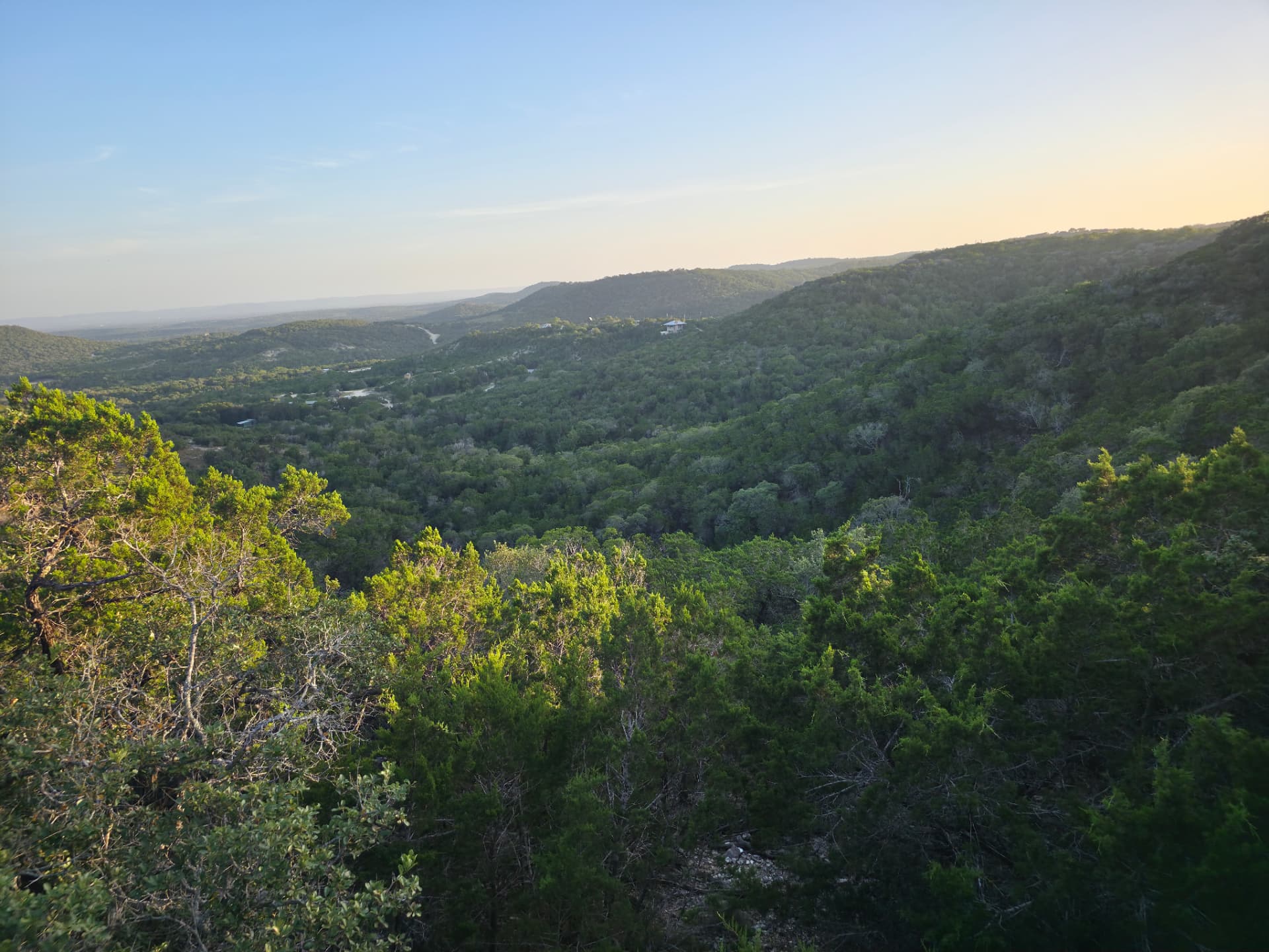 Twenty miles of Texas Hill Country ridges and cedar-covered valleys seen at golden hour from Twenty Mile View Cottage in rural Kerr County