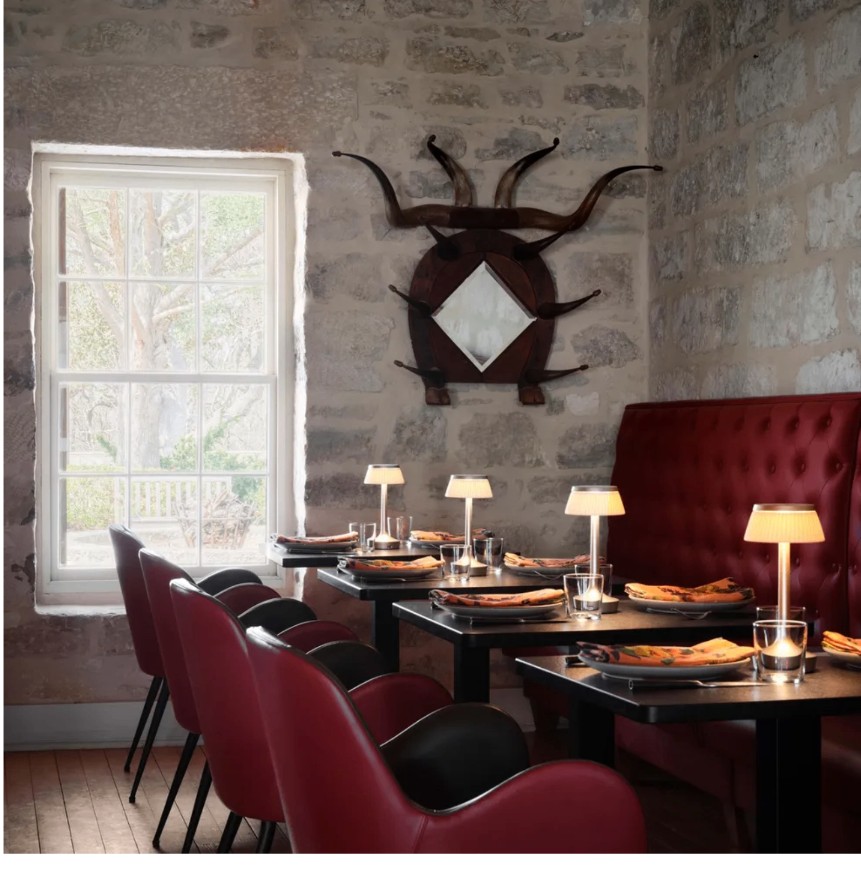 Dining room with limestone walls and red banquette seating at Zanzenberg Tavern