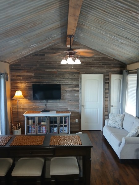 Furnished living area inside Twenty Mile View Cottage with vaulted ceiling and reclaimed wood wall